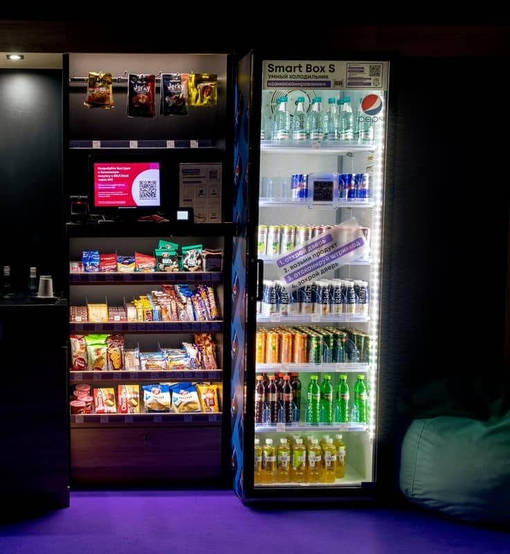 Illuminated snack and drink vending machines in a dimly lit lounge area