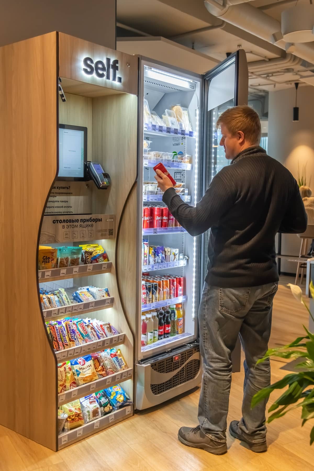 Man using a self-checkout micro market unit in an office